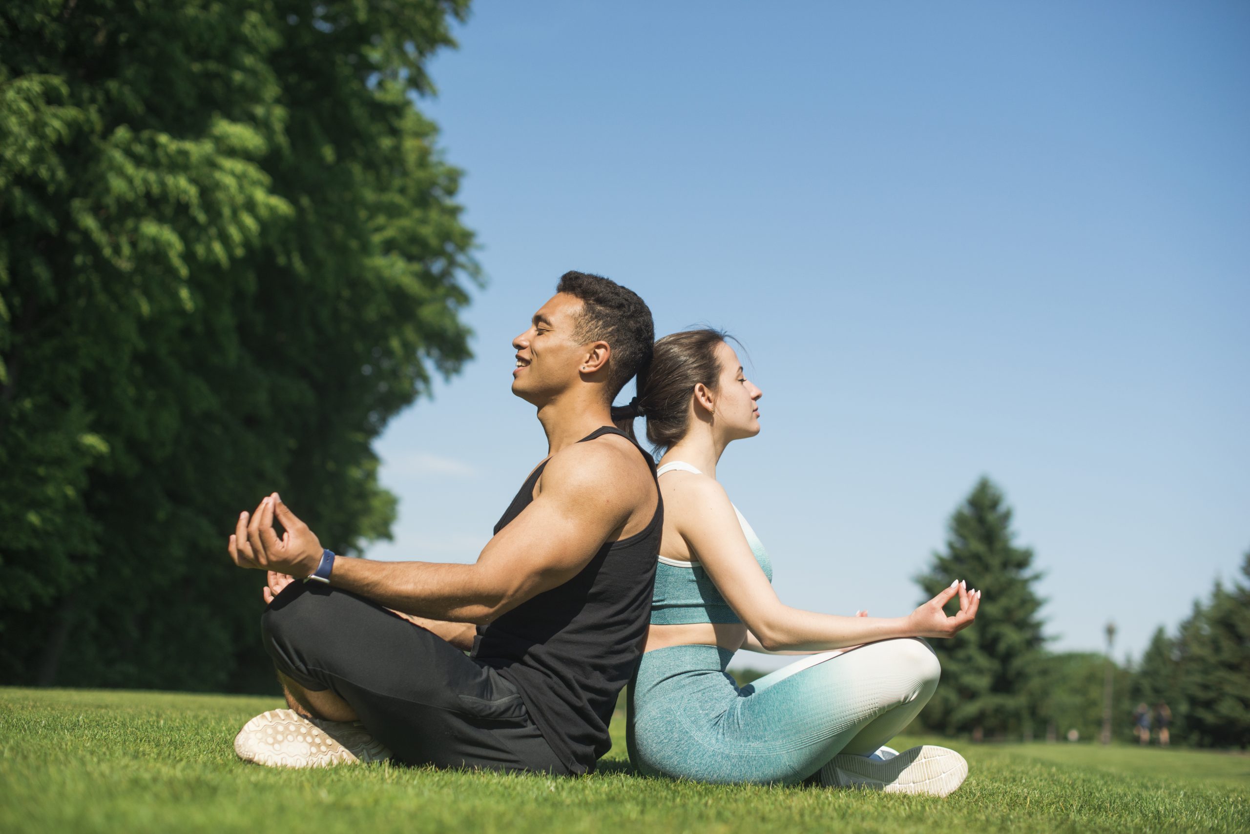 Man and woman practicing yoga outdoors